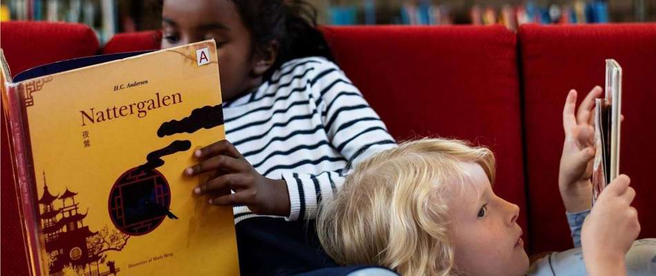 2 børn læser på skolebiblioteket